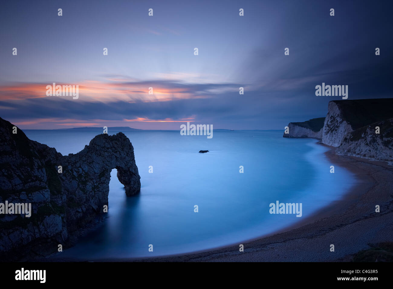 Durdle Door and the Jurassic Coast at dusk, with Weymouth Bay & Portland beyond, Dorset, England Stock Photo