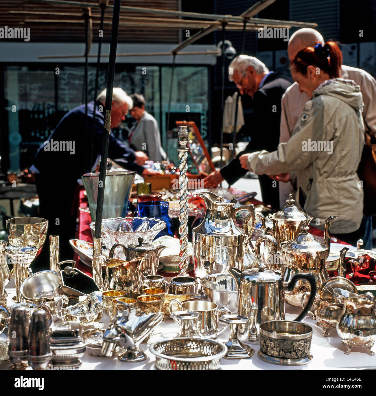 People tourists browsing silver at a silverware stall at Bermondsey Antiques Flea Market in South London street market England UK KATHY DEWITT Stock Photo