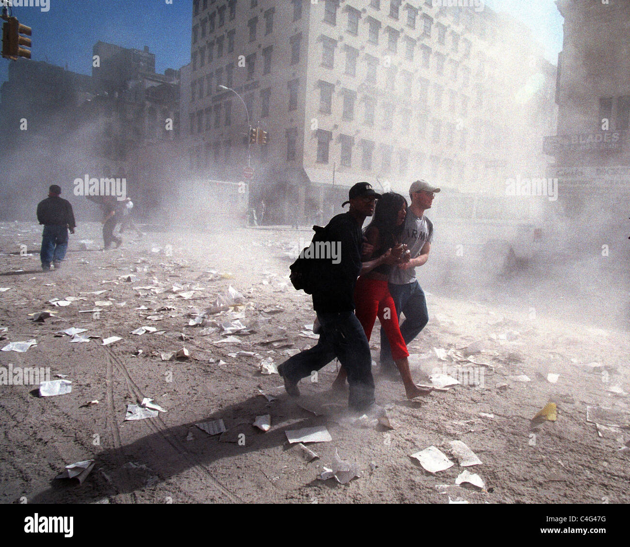 People attempt to escape the debris and concrete dust in the air on September 11, 2001 after WTC terrorist attack Stock Photo