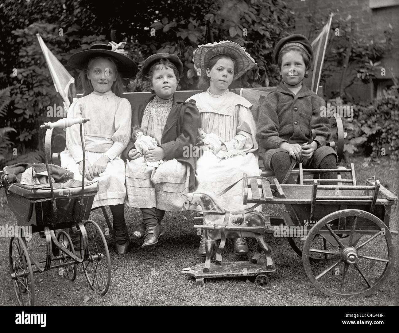 Original glass negative slide of privileged upper class Victorian or Edwardian children sitting in garden with many toys Stock Photo