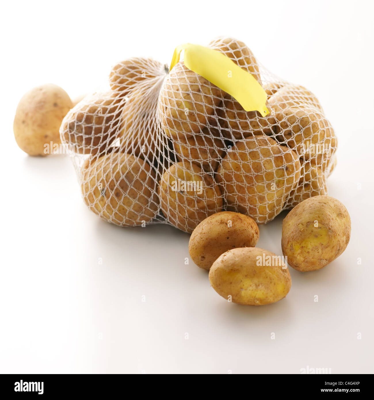 Bag of fresh potatoes with price tag on white background Stock Photo