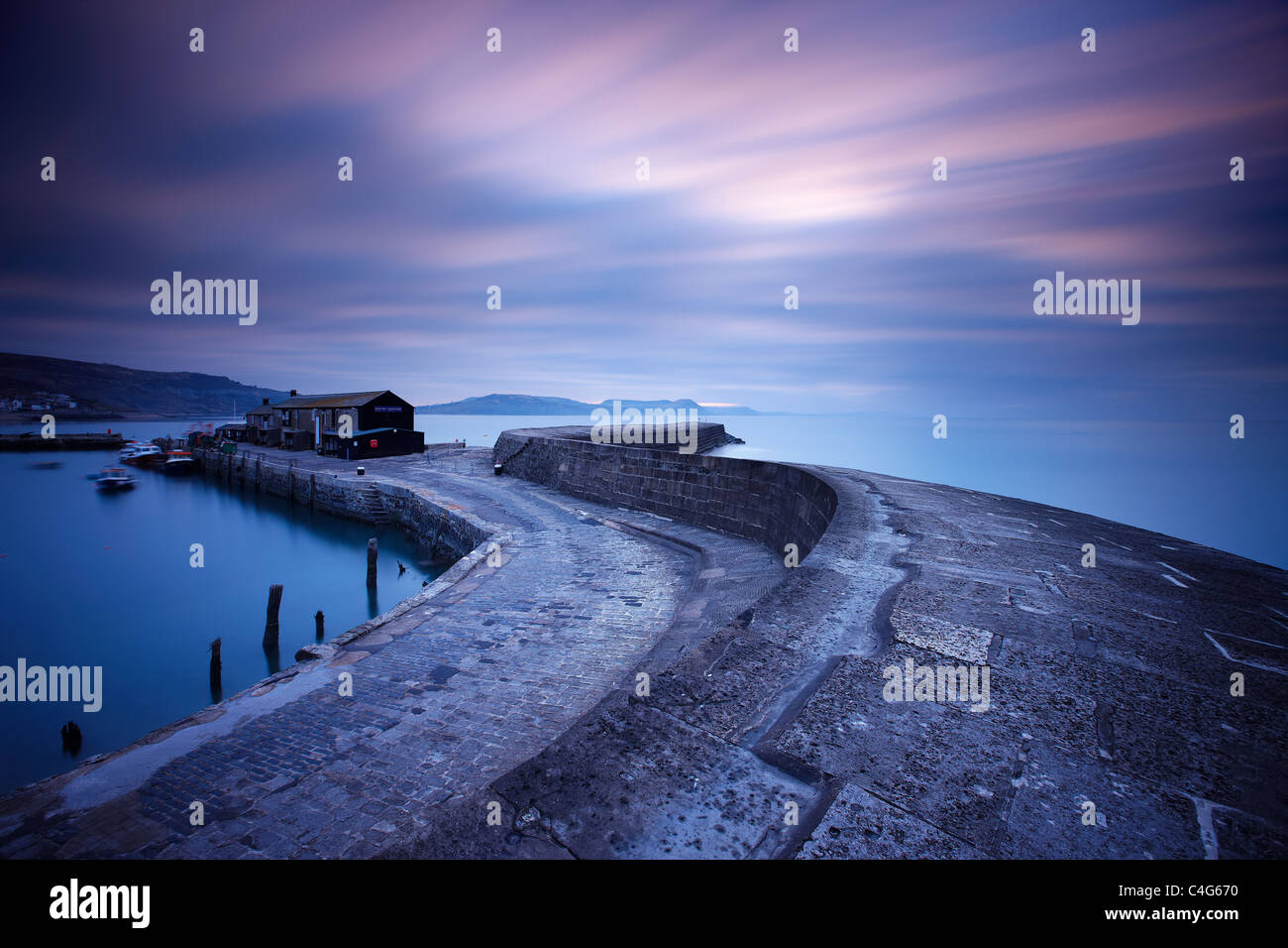 the Cobb at Lyme Regis at dawn with the Jurassic Coast beyond, Dorset, England, UK Stock Photo