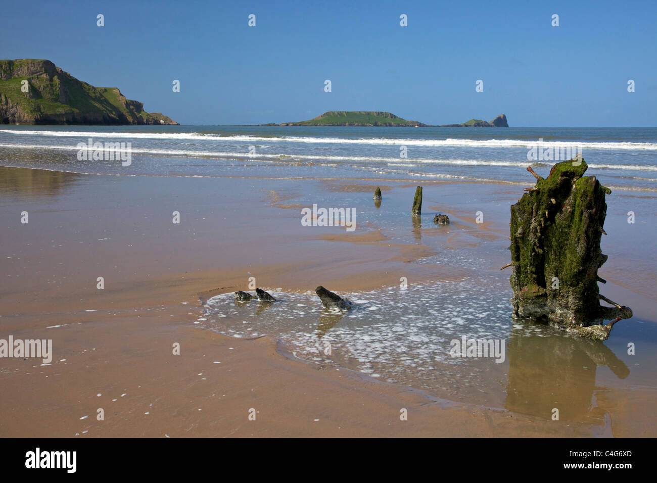 Wreck of the Helvetia on Rhossili beach in spring sunshine looking to Worm's Head Gower Peninsula Wales Cymru UK GB Stock Photo