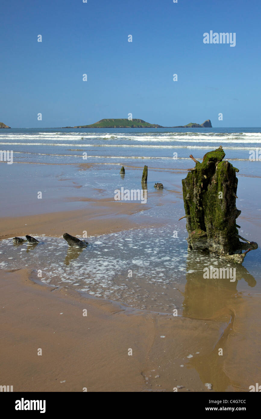 Wreck of the Helvetia on Rhossili beach in spring sunshine looking to Worm's Head Gower Peninsula Wales Cymru UK GB Stock Photo