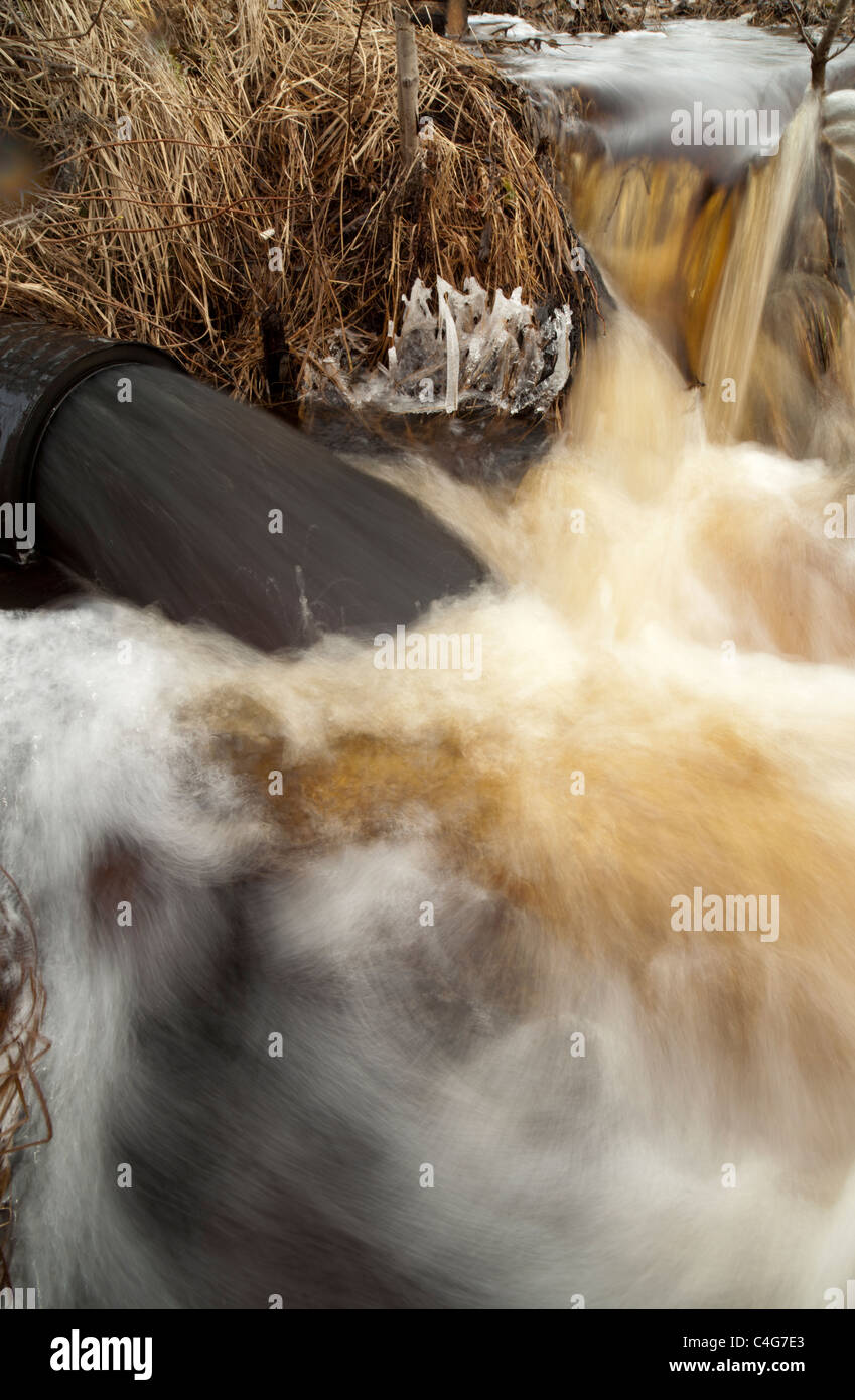 Drainpipe  spewing out black water , Finland Stock Photo