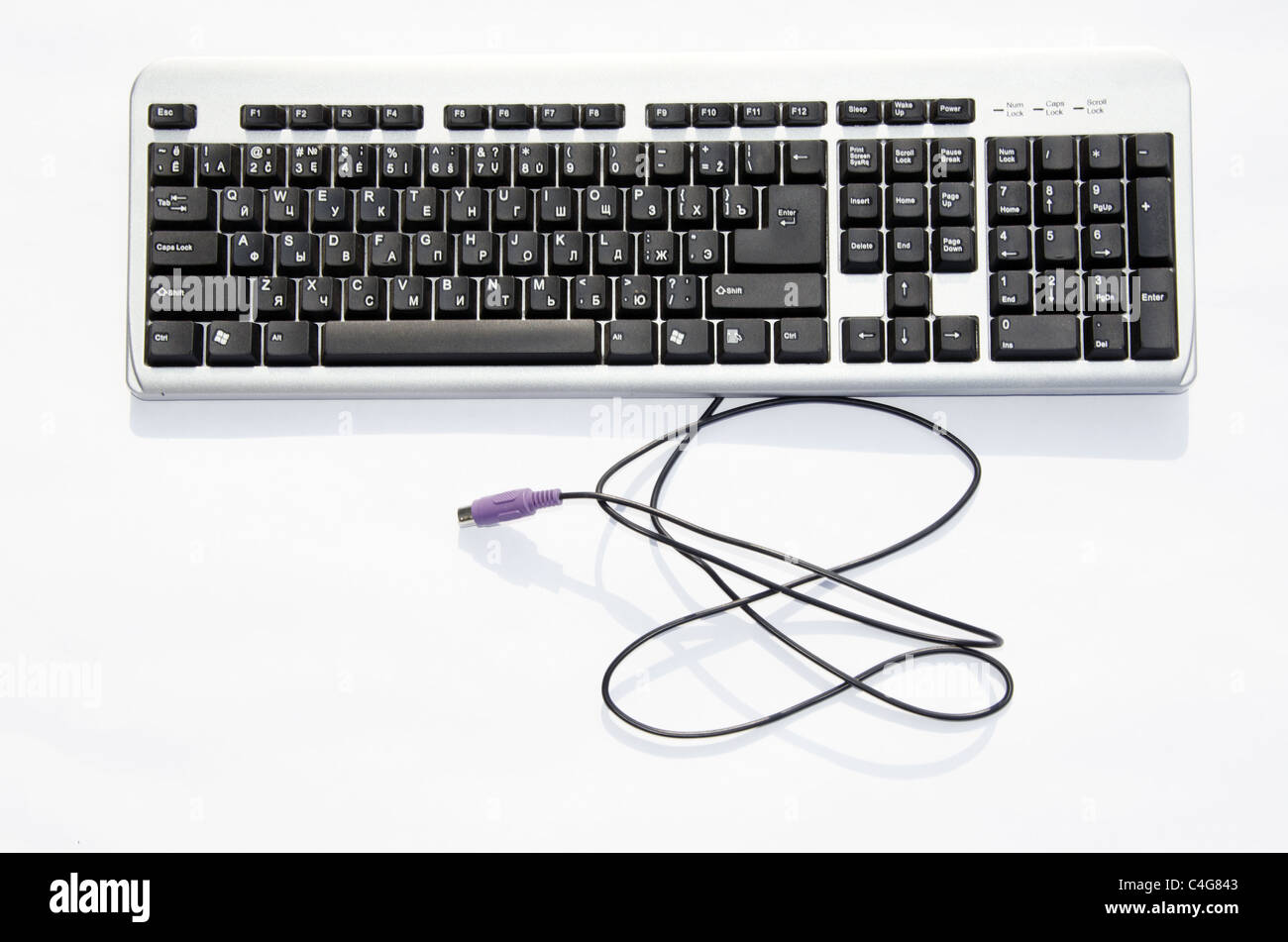 Computer keyboard with blue PS2 connector isolated on a white background. Lithuanian and russian letters. Stock Photo