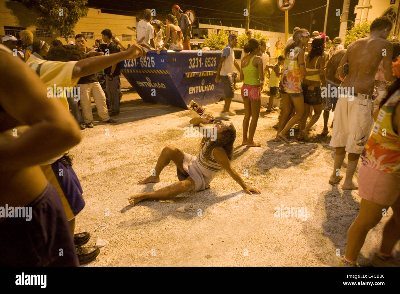 Street Carnival Community party known as Carnavila Drunk man dressed as woman drinking cachaca Stock Photo