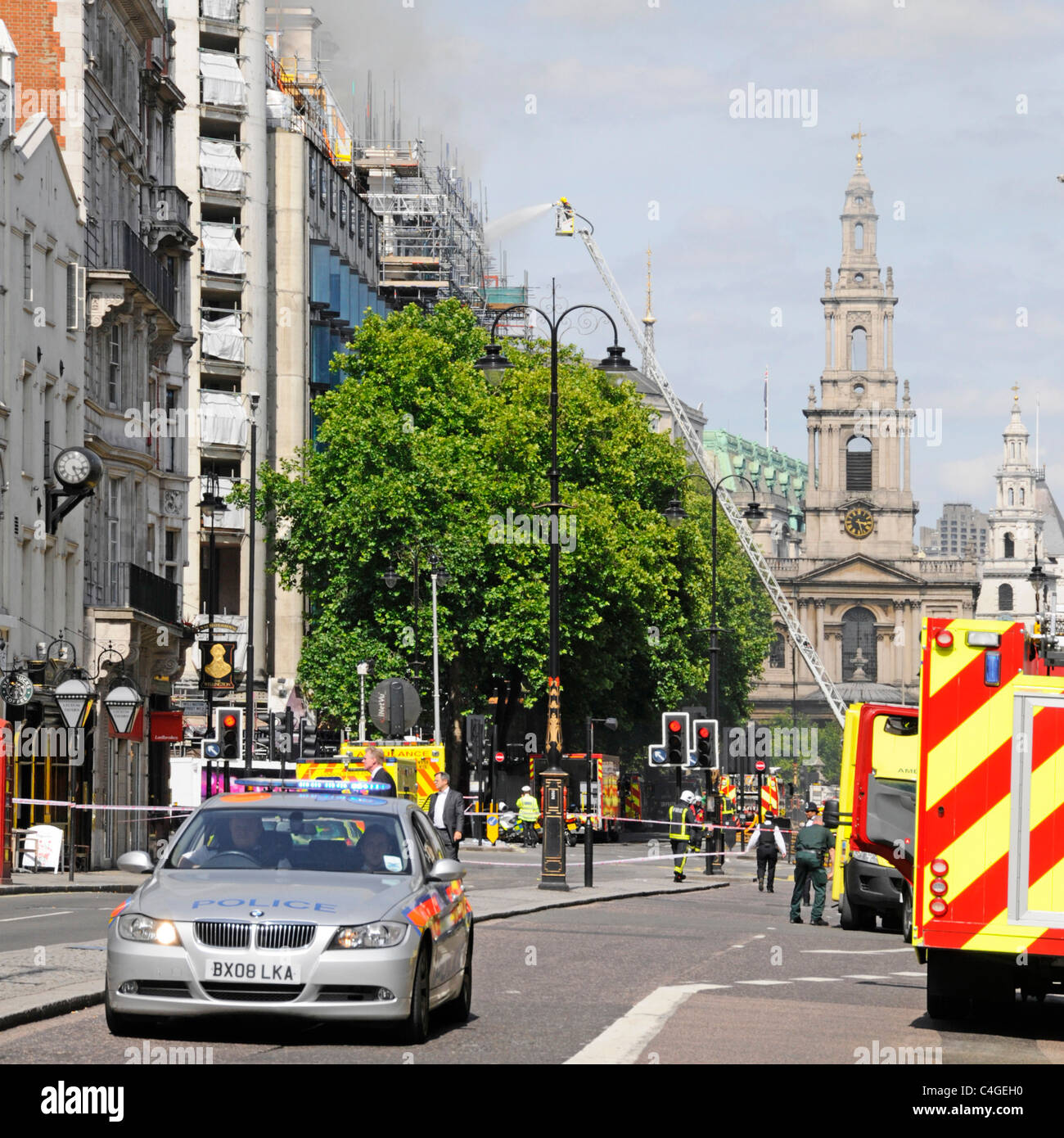 St Mary Le Strand Church tower stands beyond firefighter on telescopic access platform at major fire in Marconi House Aldwych Stock Photo