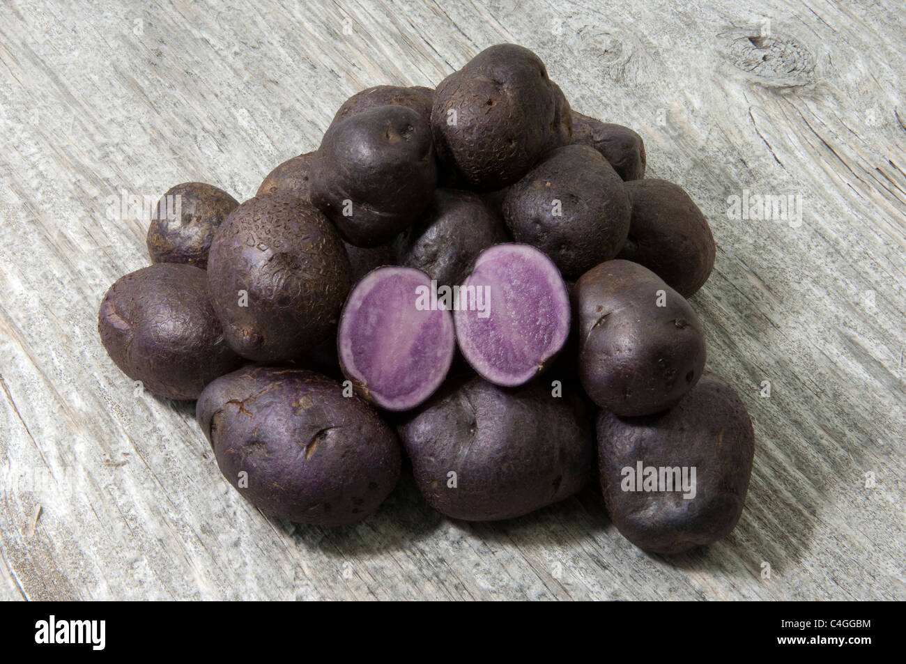 Potato (Solanum tuberosum Blue Congo). Potatoes on wood. Stock Photo