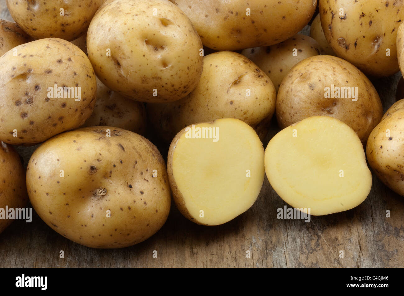 Potato (Solanum tuberosum La Bonnotte). Tubers, one of them halved. Stock Photo