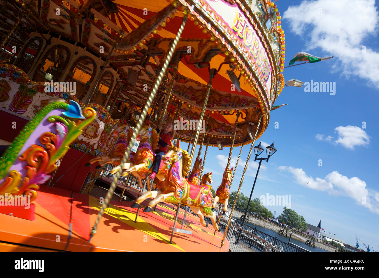 Merry-go-round on Roald Dahl Plass, Cardiff Bay, spring sunshine, Cardiff, South Glamorgan UK GB Stock Photo
