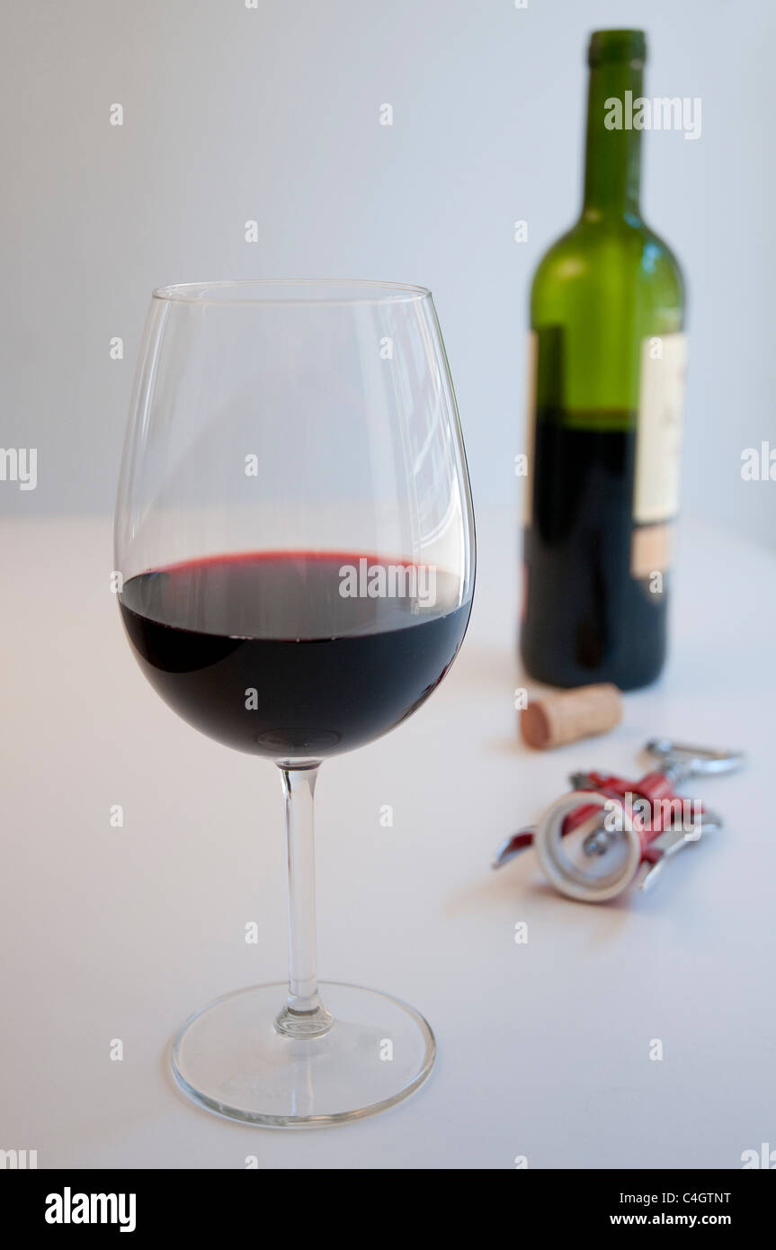 Glass of red wine, cork, corkscrew and bottle. Still life. Stock Photo