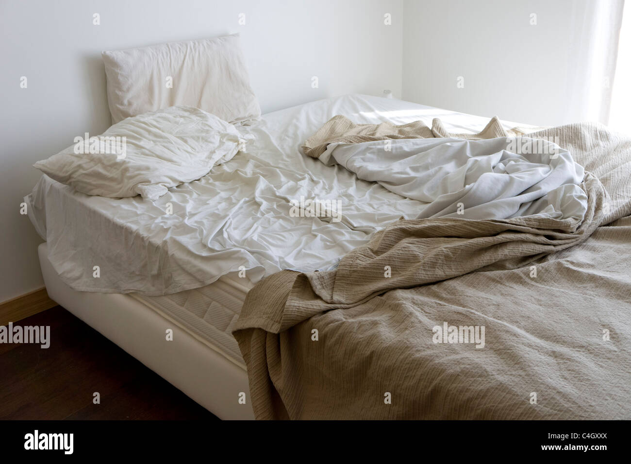 Unmade bed in a messy bedroom Stock Photo - Alamy