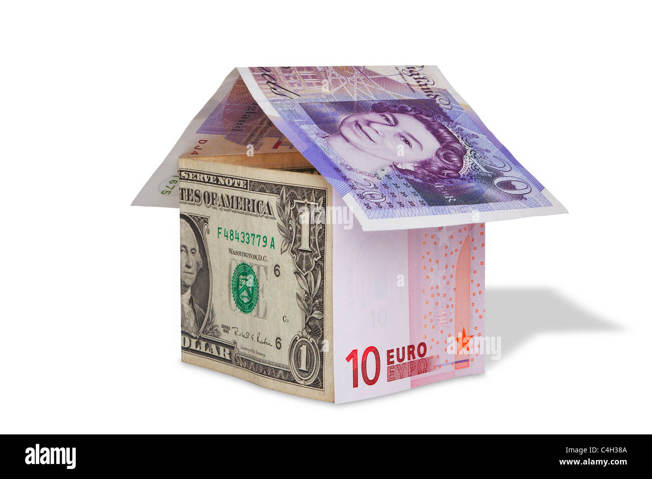 Photo of a house made from British Pound, US dollar and Euro banknotes, isolated on white with clipping path. Stock Photo