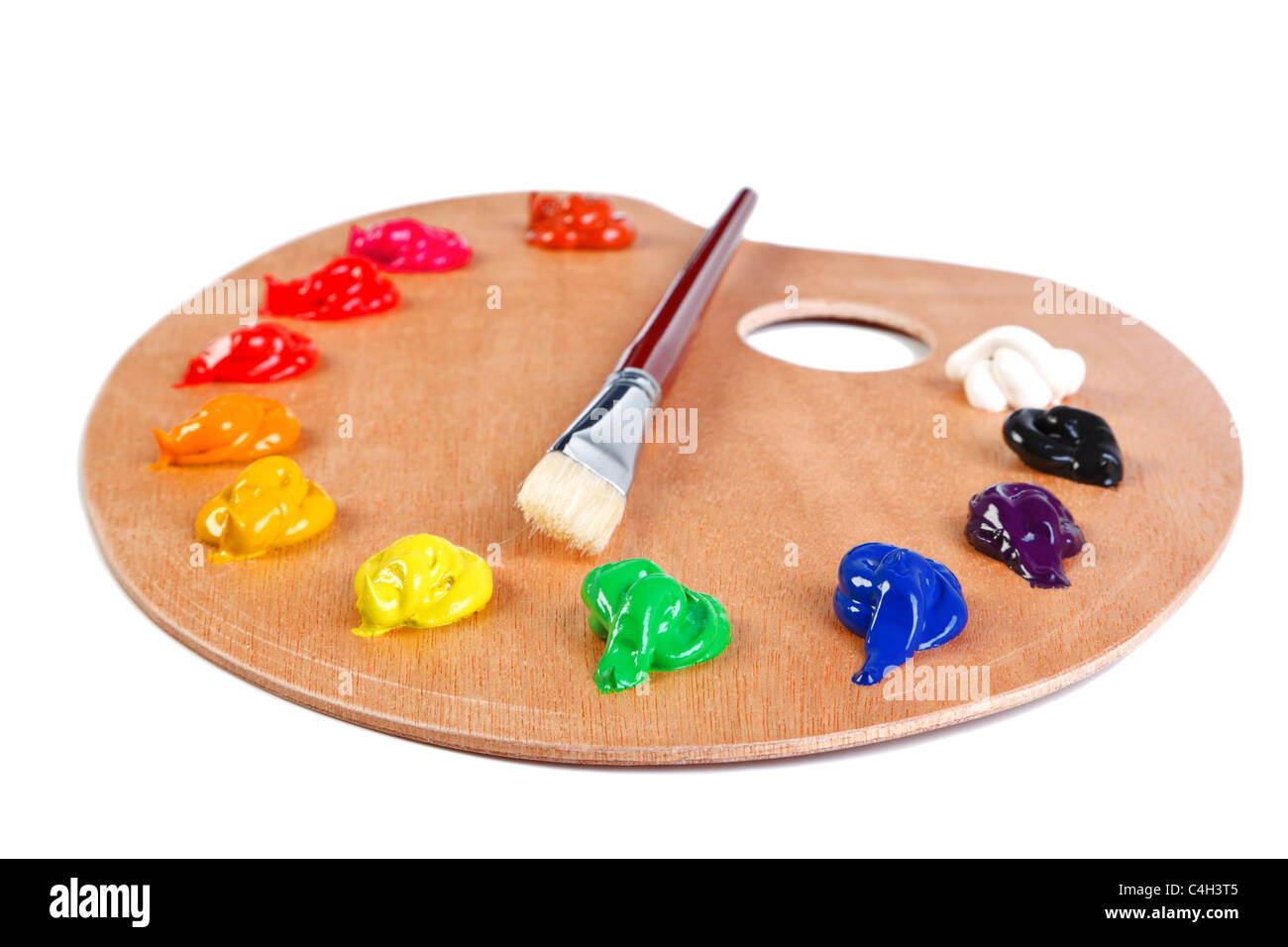Photo of a wooden artists palette loaded with various colour paints and brush, isolated on a white background with clipping path Stock Photo