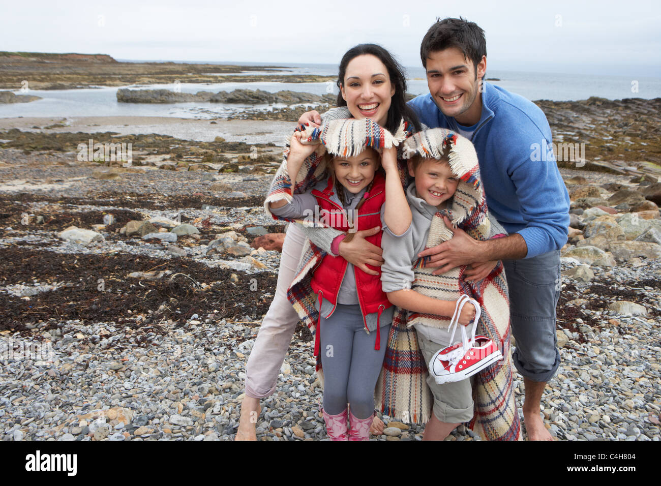 Family on beach with blankets Stock Photo