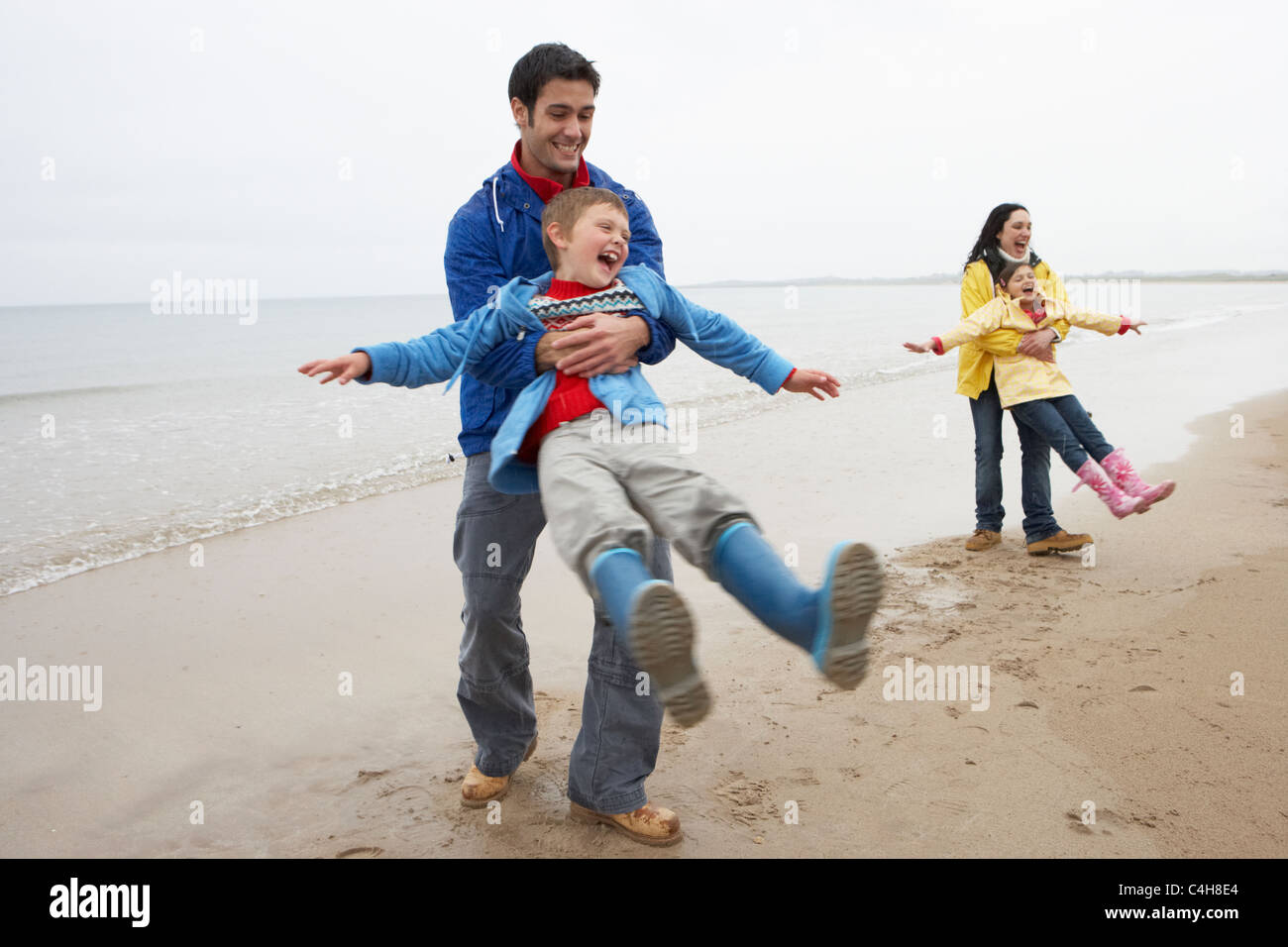 Family playing on beach Stock Photo