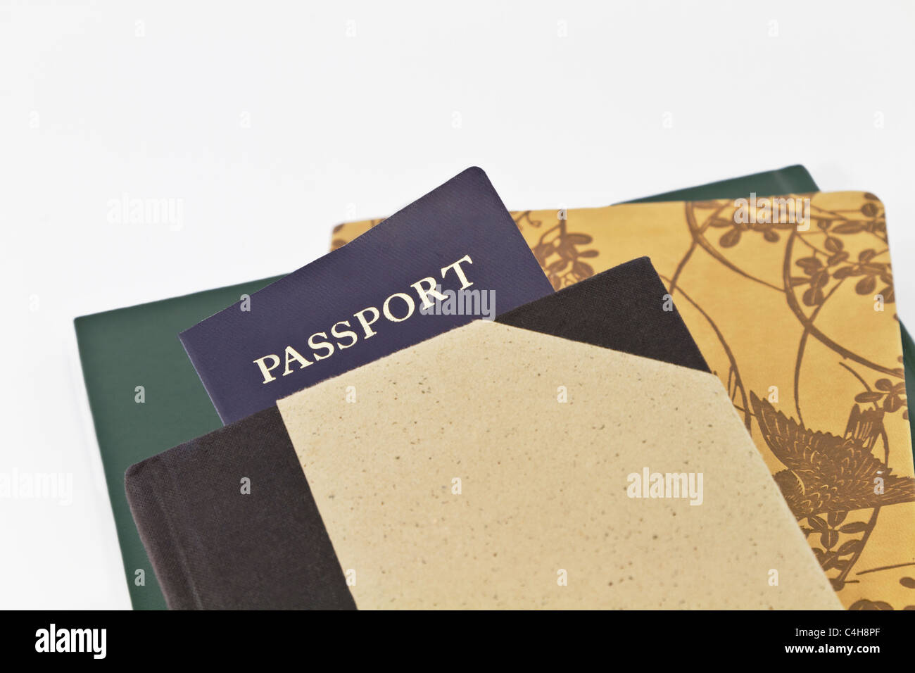 Close up of passport placed with several journals. Image of travel, academic study abroad, writing, volunteerism, and adventure. Stock Photo