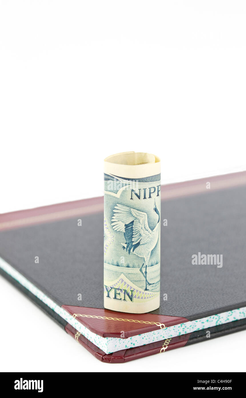 Yen currency stands on accounting ledger; copy space above; shallow depth of focus. Stock Photo