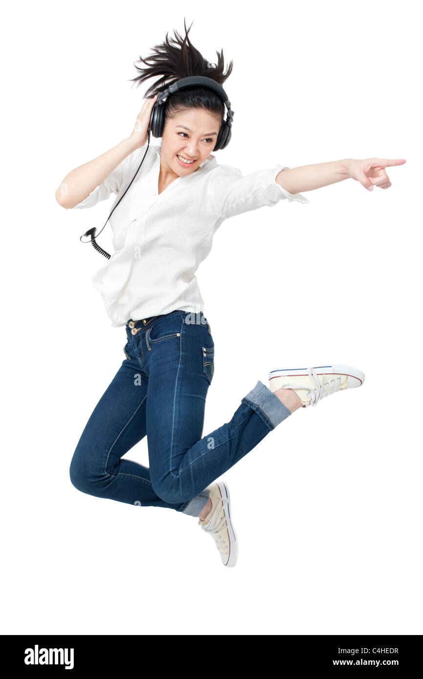 Young woman dancing while listening to headphones Stock Photo - Alamy