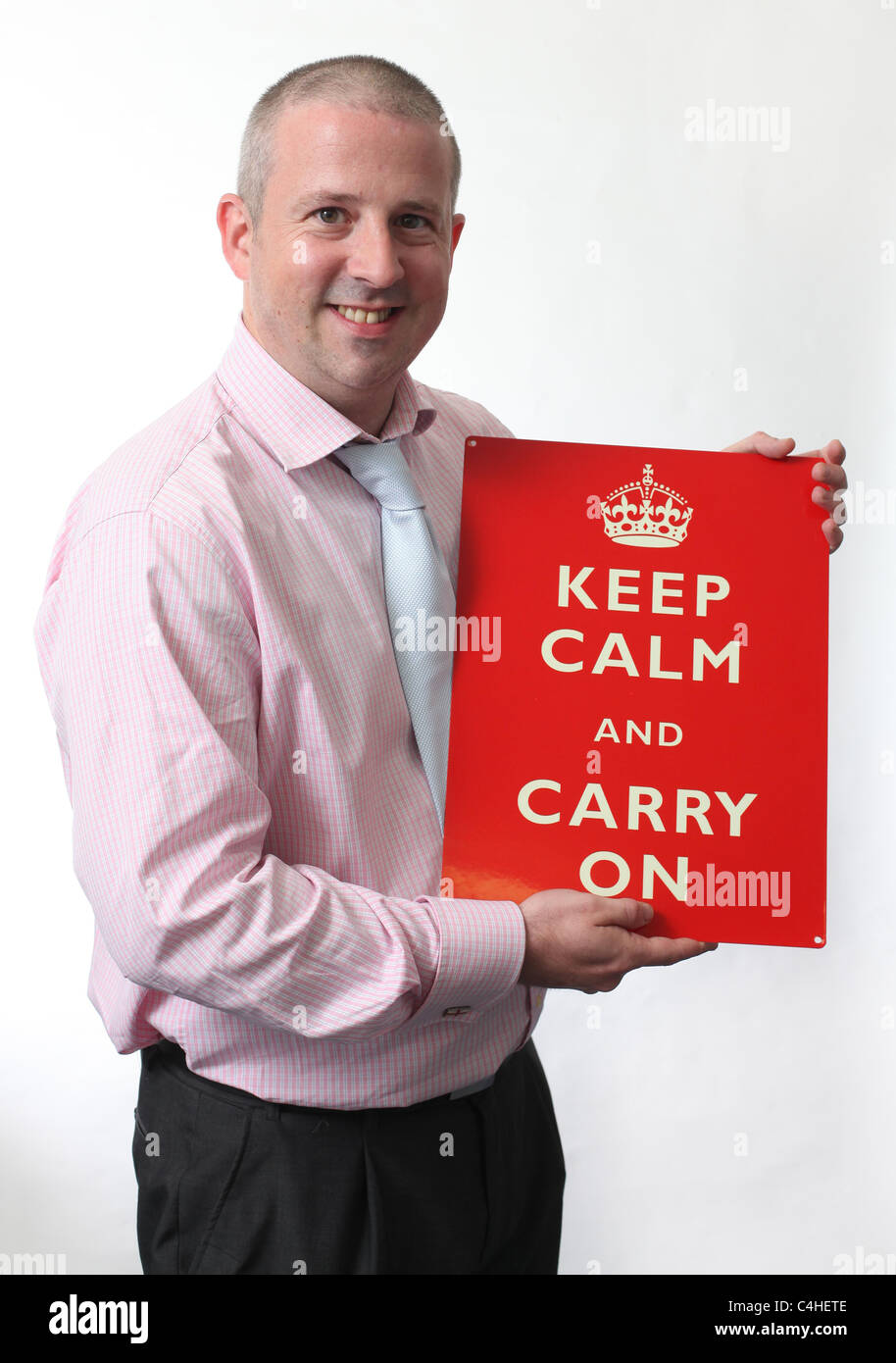 Man holding a Keep Calm And Carry On sign. Picture by James Boardman. Stock Photo