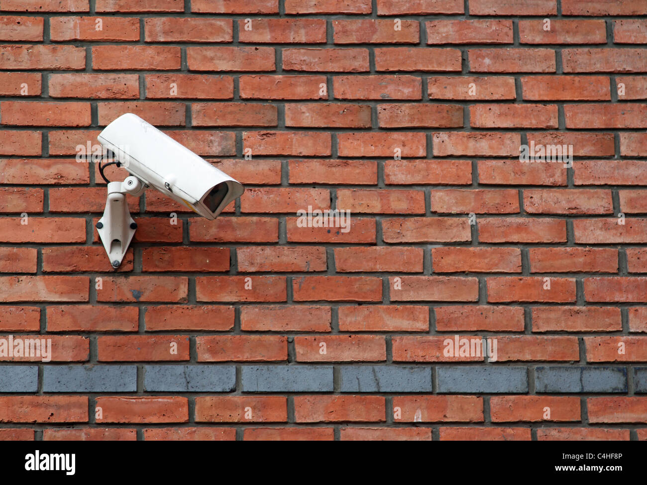 white CCTV camera mounted on a red brick wall Stock Photo Alamy