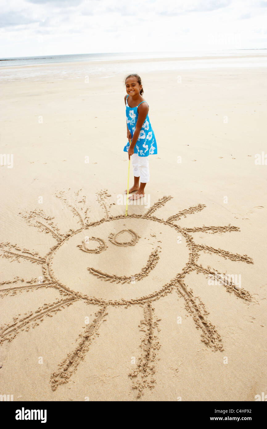 Girl drawing in sand Stock Photo