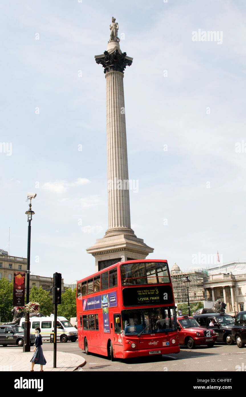 A red London bus on route 3 passes Nelsons column in Trafalgar Square, London Stock Photo