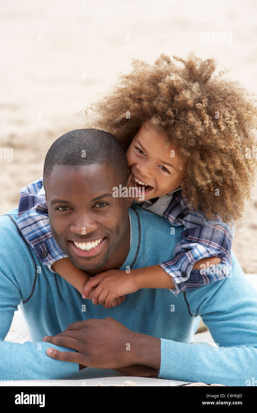 Father and son playing piggyback on beach Stock Photo