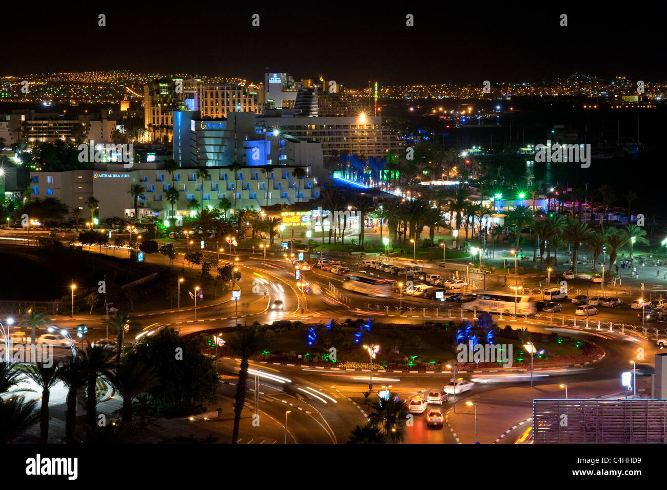 A view of the hotel and beach area of Eilat at night with the lights of Aqaba in the background. Stock Photo