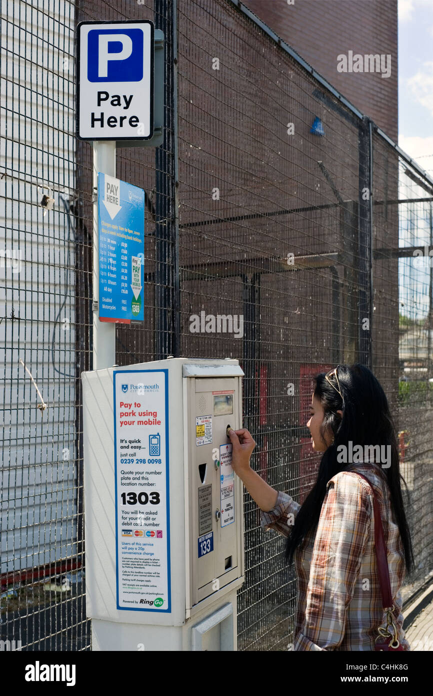 woman putting coin into car parking meter Stock Photo Alamy