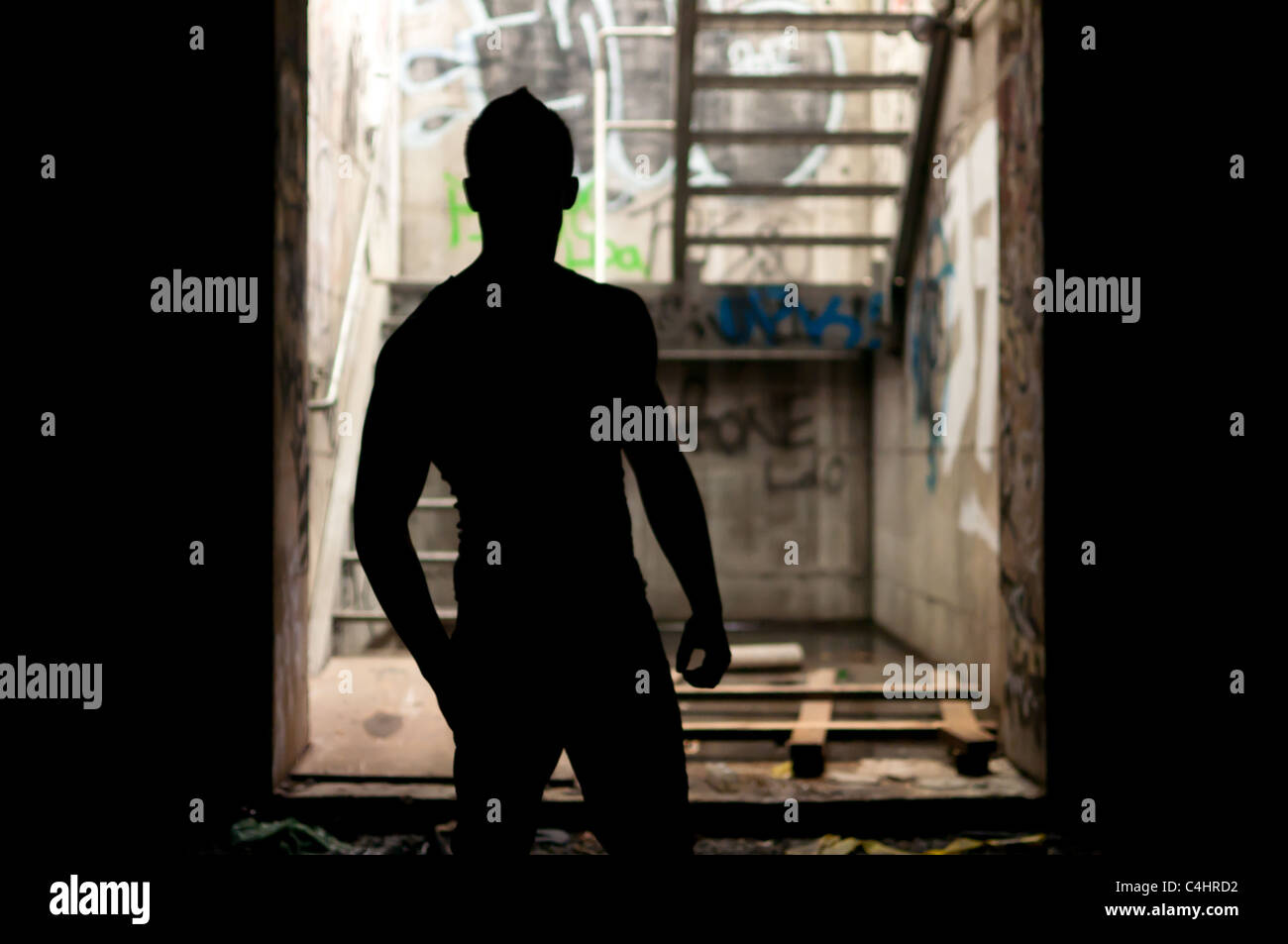 Dark silhouette of a man in an abandoned staircase Stock Photo