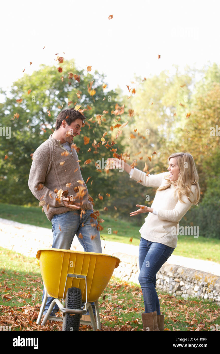 Young couple having fun with autumn leaves in garden Stock Photo