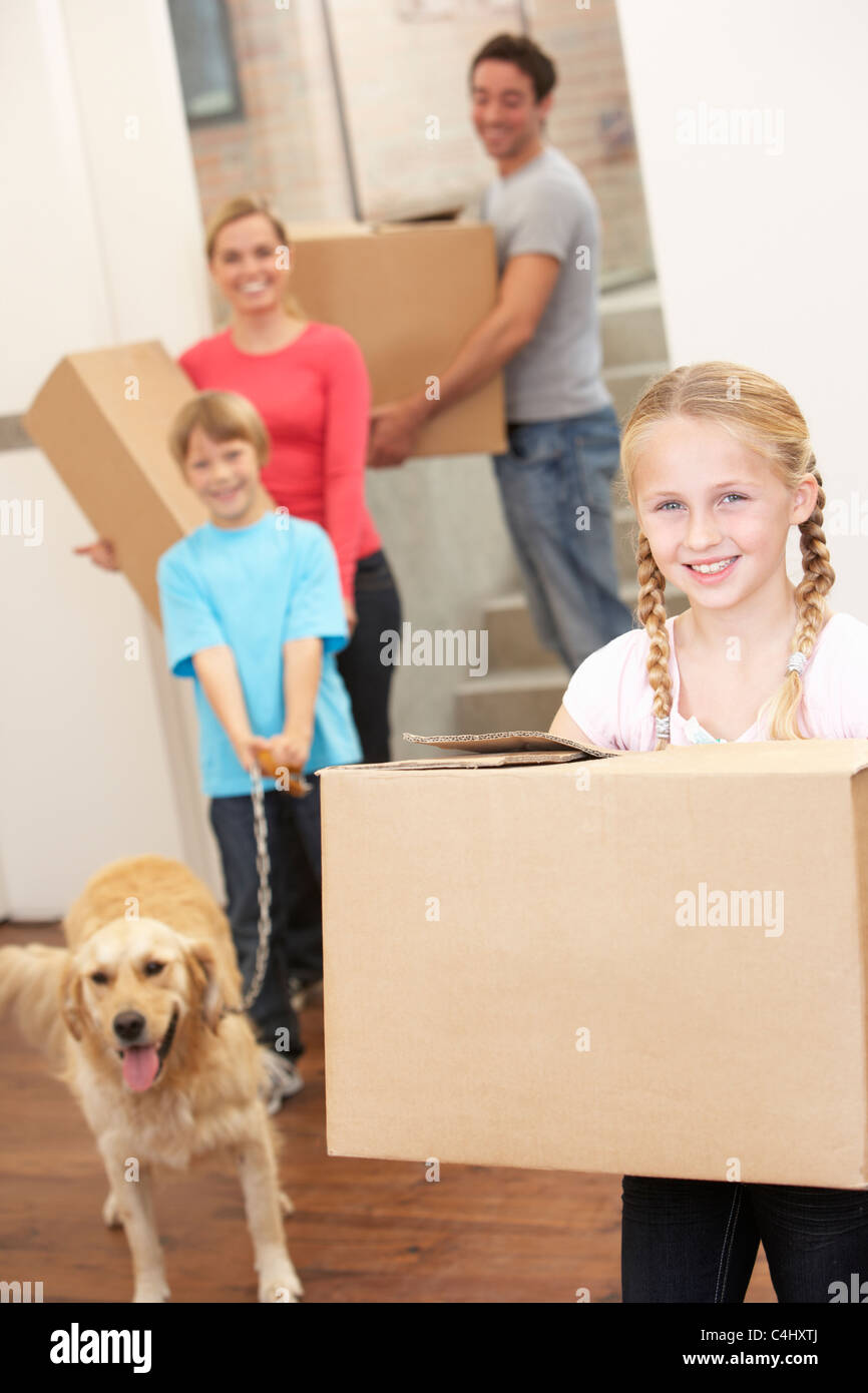 Family with dog on moving day carrying cardboard boxes Stock Photo