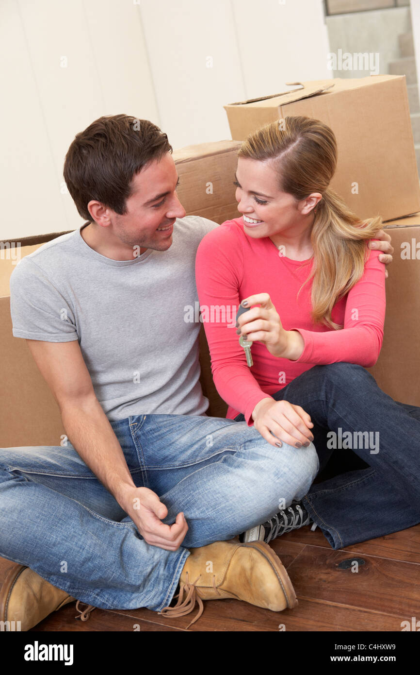 Young couple on moving day sitting with cardboard boxes Stock Photo