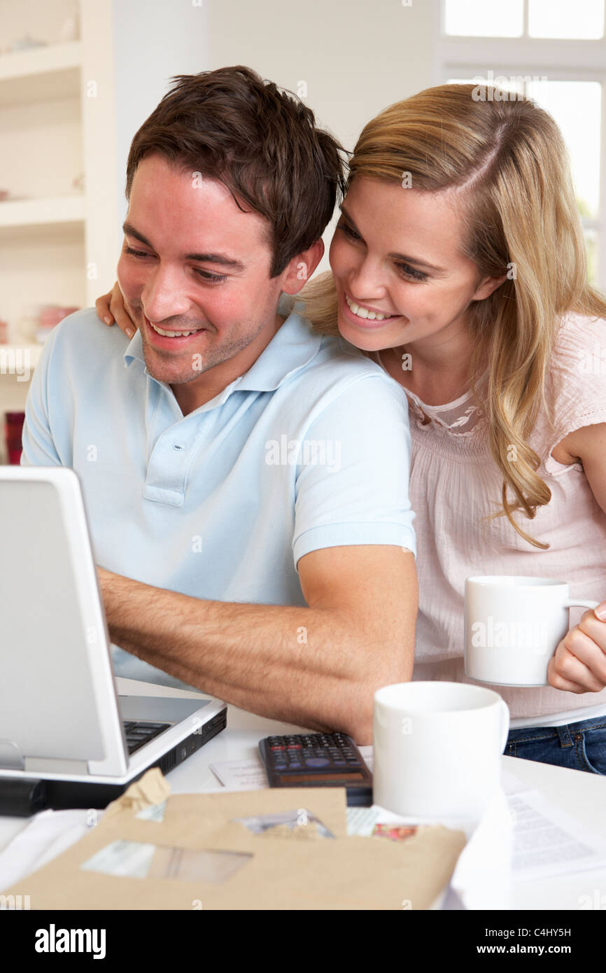Happy young happy couple looking and reading a laptop computer Stock Photo