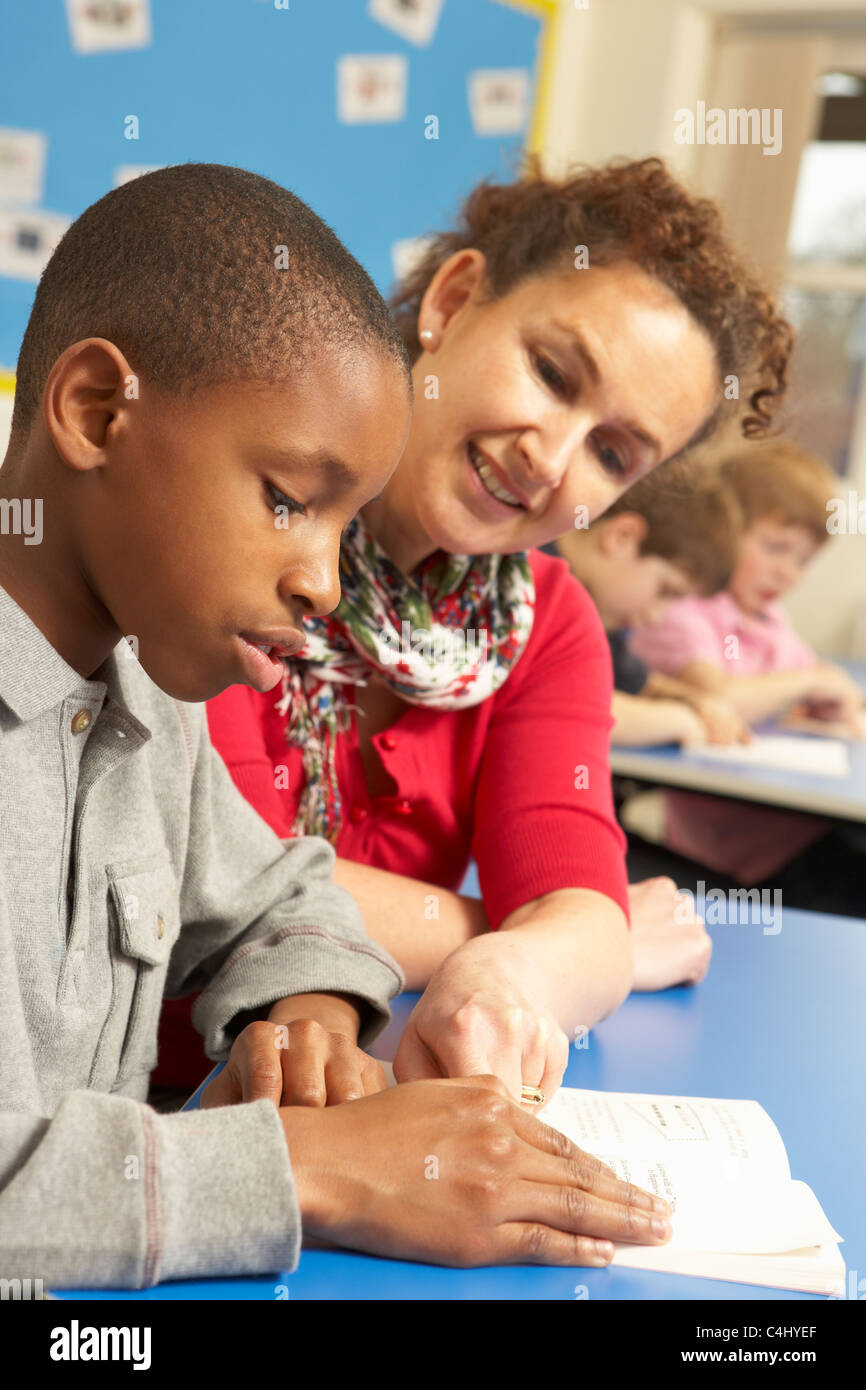 Schoolboy Studying In Classroom With Teacher Stock Photo