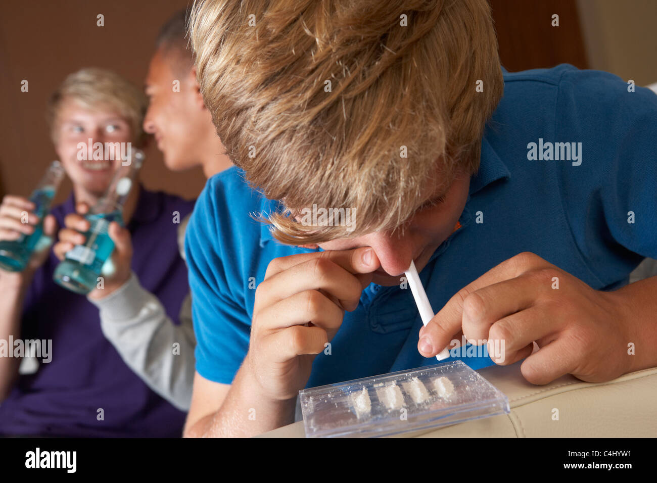 Group Of Teenage Boys Taking Drugs At Home Stock Photo