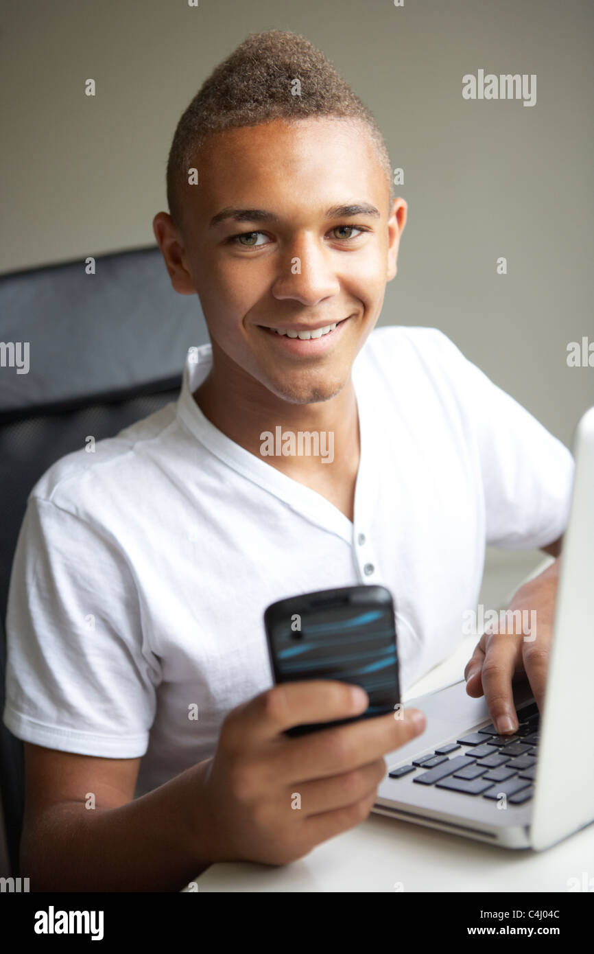 Teenage Boy Using Laptop And Mobile At Home Stock Photo - Alamy