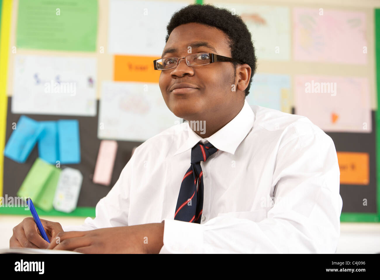 Male Teenage Student Studying In Classroom Stock Photo
