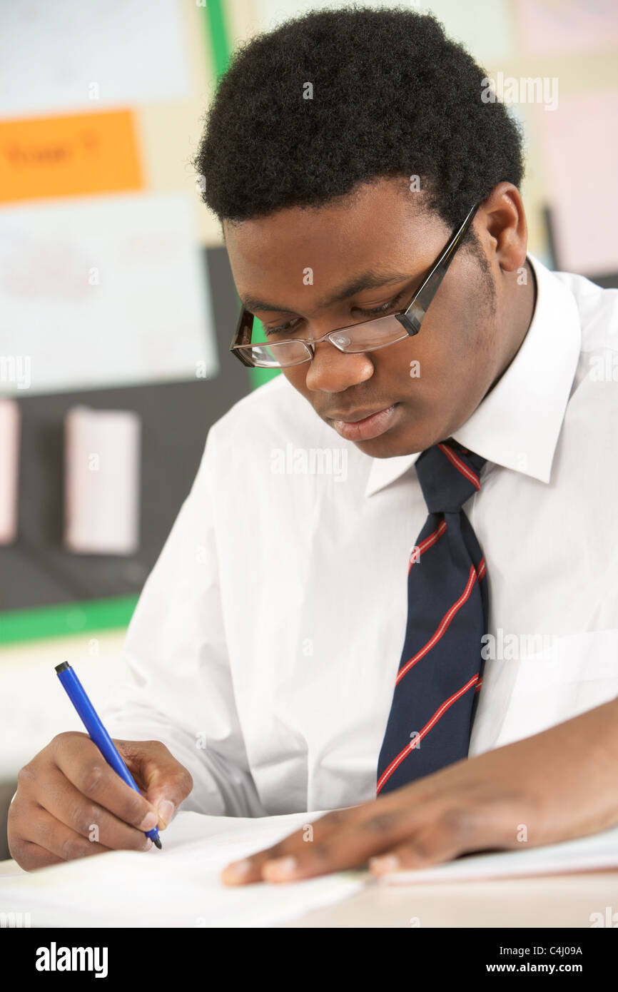 Male Teenage Student Studying In Classroom Stock Photo