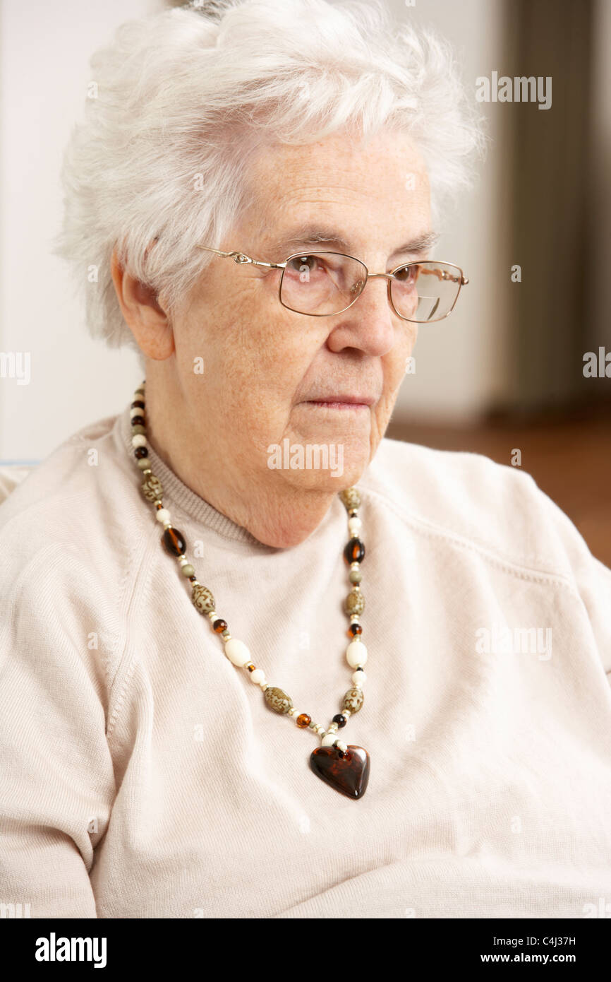 Senior Woman Looking Sad In Chair At Home Stock Photo - Alamy