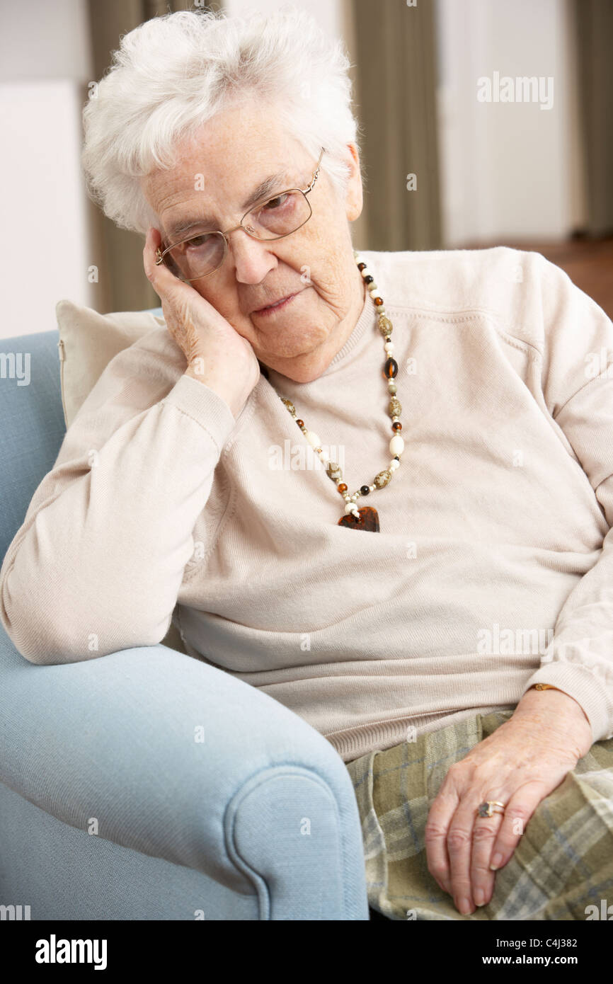 Senior Woman Looking Sad In Chair At Home Stock Photo - Alamy