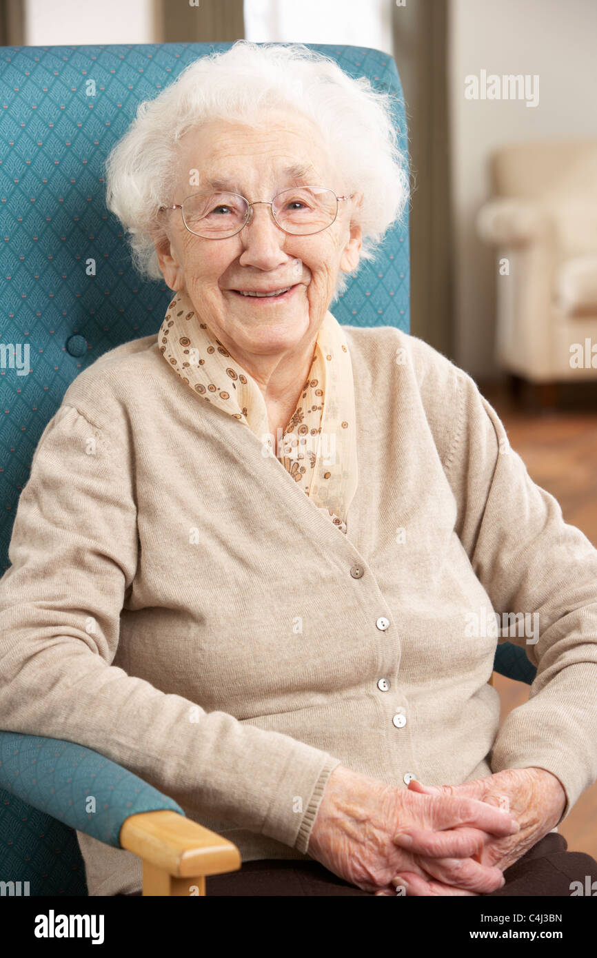 Senior Woman Relaxing In Chair At Home Stock Photo