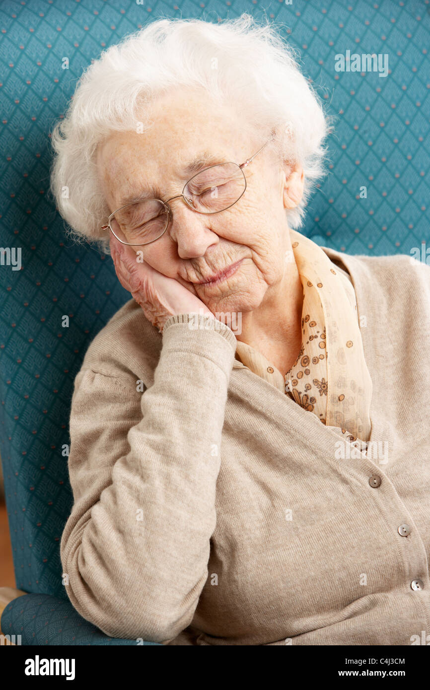 Senior Woman Resting In Chair At Home Stock Photo