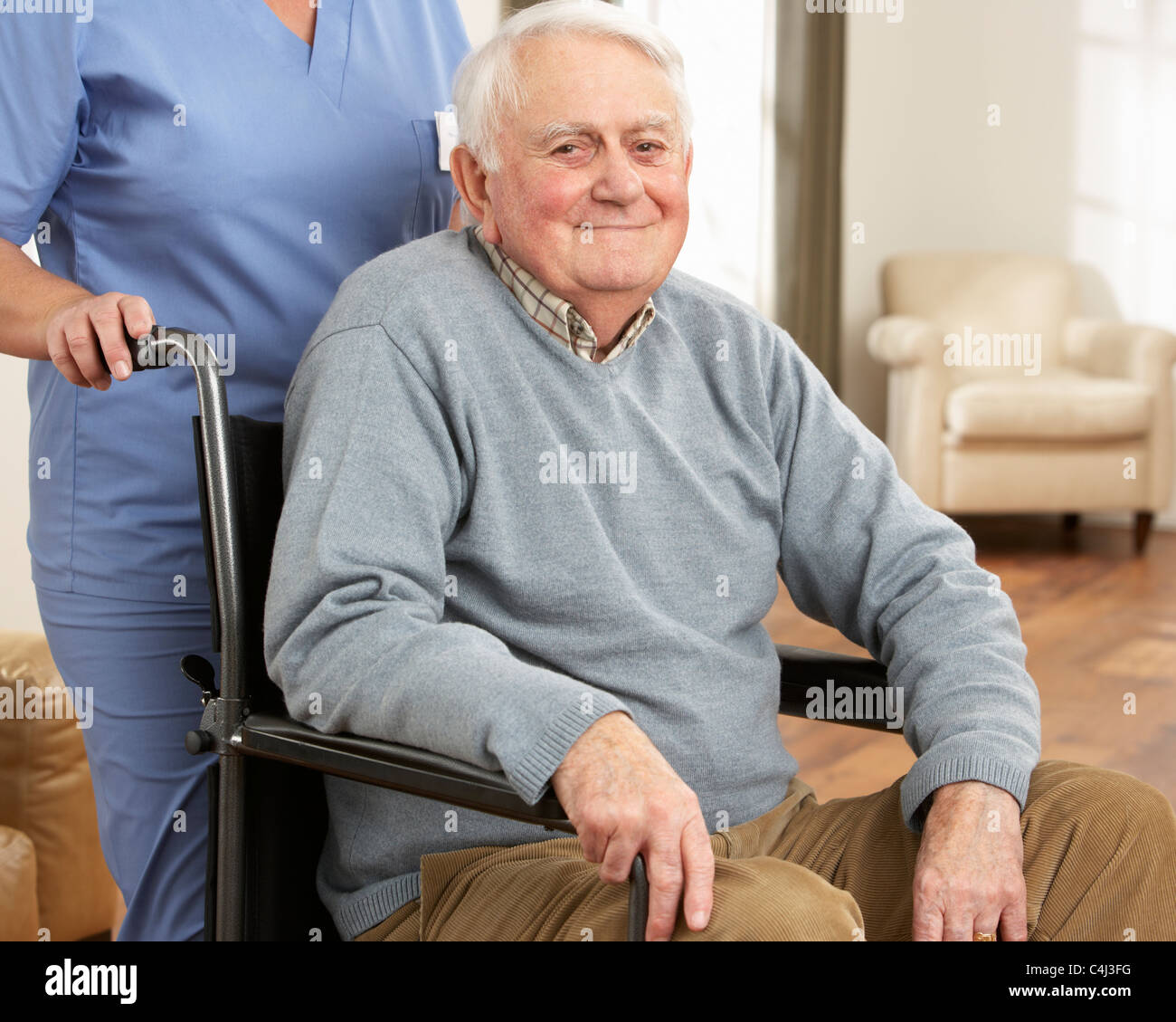 Disabled Senior Man Sitting In Wheelchair With Carer Behind Stock Photo