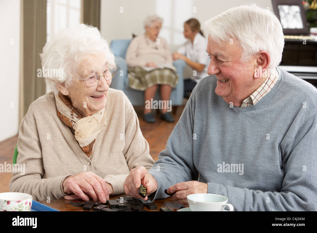 Couple Playing Dominoes At Day Care Centre Stock Photo