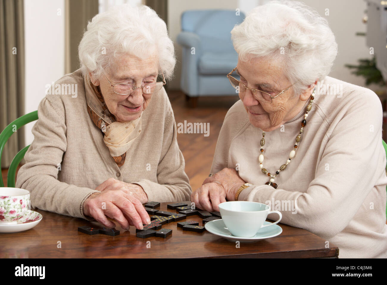 Two Senior Women Playing Dominoes At Day Care Centre Stock Photo
