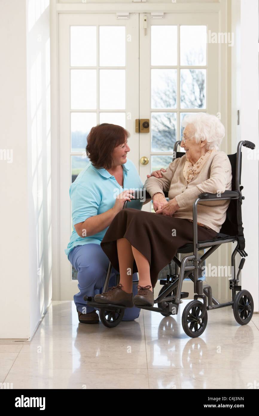 Carer With Disabled Senior Woman Sitting In Wheelchair Stock Photo