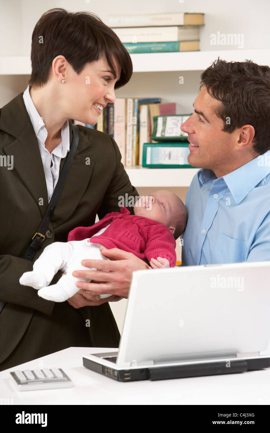 Working Mother Leaving Baby With Father Who Works From Home Stock Photo